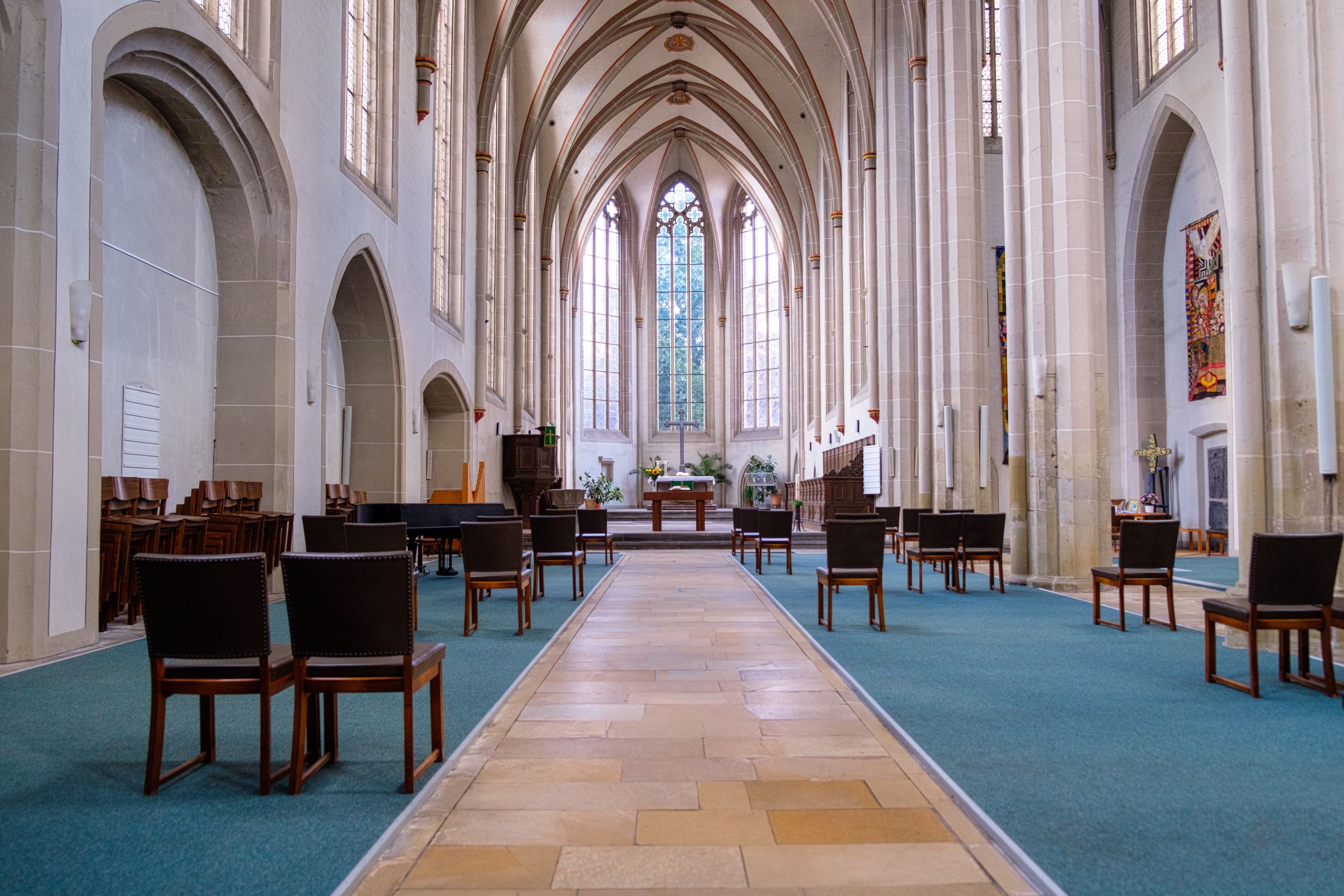 Gothic-style church interior with rows of chairs and an ornate altar.
